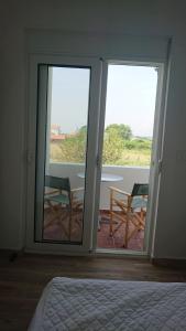 sypialnia z drzwiami na balkon z 2 krzesłami w obiekcie Luce di Sole Apartment w Ulcinju