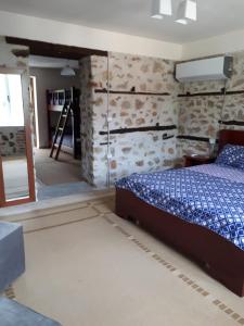 um quarto com uma cama num quarto com paredes de pedra em Bona's Home em Tushemisht