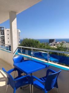 un tavolo blu e sedie su un balcone con vista sull'oceano di Apartmani Dini a Ulcinj