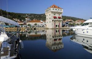 einen Turm im Wasser mit Booten in einem Yachthafen in der Unterkunft Apartments Ivana-Gustirna in Gustirna