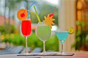 three cocktails sitting on top of a table at Royal Crown Hotel & Spa in Siem Reap