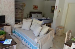 a living room with a couch and two beds at Blue Ark Aigeira Flat & Studio in Aíyira