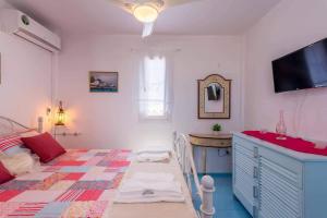 a bedroom with a bed and a television in it at BLUE PARADISE SUITES in Pachaina