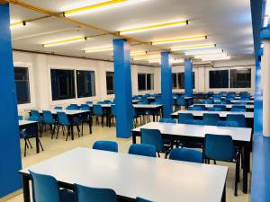 a room with tables and chairs and blue chairs at Alberg Deltebre Xanascat in Deltebre