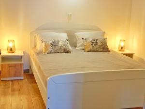 ein weißes Bett mit zwei Kissen auf einem Zimmer in der Unterkunft MILANO in Rogoznica