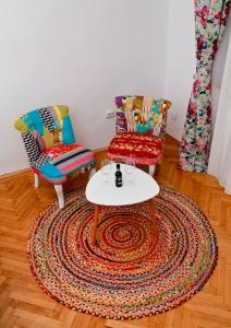 un soggiorno con 2 sedie e un tavolo di Bright Studio in the Heart of the City with Netflix a Bucarest