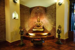 una stanza con una statua in un muro di mattoni di Thagu Chhen, a Boutique Hotel a Bhaktapur