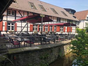 un restaurante con mesas y sillas frente a un edificio en Hotel & Gastropark Loemühle-Restaurant-Biergarten en Marl