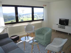 a living room with a couch and chairs and a tv at Ferienwohnung Saig in Lenzkirch