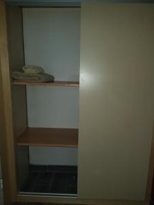 Habitación con armario y estante de madera. en cosy home, en Rabat