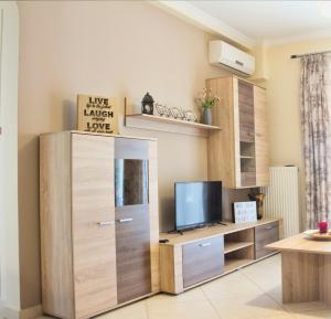 a living room with a tv and a wooden cabinet at Charming Apartment near Athens Center and the Sea in Athens