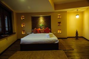 una camera da letto con un letto e un muro di mattoni di Thagu Chhen, a Boutique Hotel a Bhaktapur