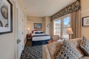 a hotel room with a bed and a window at Gaslamp Plaza Suites in San Diego