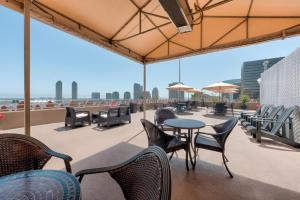 a patio with tables and chairs on a roof at Gaslamp Plaza Suites in San Diego