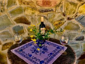 einen Tisch mit einer Flasche Wein und zwei Gläsern in der Unterkunft Kopanický dvor in Hodruša