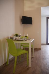 a dining room with a table and green chairs at Brezza di Stagnone in Birgi Vecchi