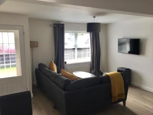 a living room with a couch and a table at 1 Shiphouse Apartment in Lamlash