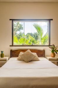 ein Schlafzimmer mit einem Bett mit einem großen Fenster in der Unterkunft Residencial Solares in Trancoso