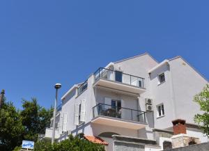 un bâtiment blanc avec un ciel bleu en arrière-plan dans l'établissement Marlin Apartments, à Dubrovnik