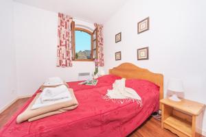 1 dormitorio con cama roja y manta roja en Résidence Vignec Village by Actisource, en Vignec