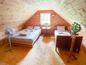 a room with a bed and a table in a attic at Nature Guest House in Võsu