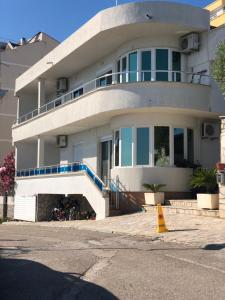 a large white house with a balcony on top of it at Apartmani Dini in Ulcinj