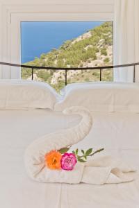 a white bed with two roses and a towel at Mountain & Sea Villa in Kyra Panagia