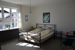 1 dormitorio con cama, mesa y ventanas en Ferie På Toppen, en Skagen