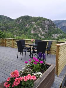 a patio with chairs and a table and flowers at Dada Apartment in Hjelmeland