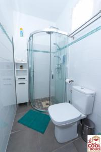 a bathroom with a toilet and a glass shower at Kouleur Karayib in Le Gosier