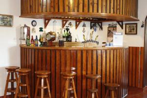 - un bar en bois avec tabourets dans la chambre dans l'établissement Monte do Parral, à Santiago do Cacém