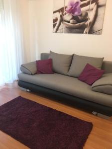 um sofá numa sala de estar com um tapete roxo em ROSE Apartman em Debrecen