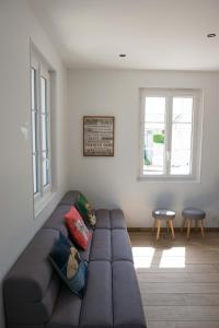 a living room with a couch and two windows at Villa Clarisse in Deauville