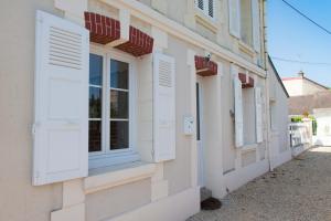 a facade of a building with white windows and shutters at Villa Clarisse in Deauville