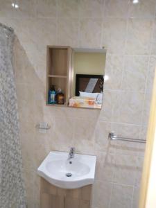 a bathroom with a white sink and a mirror at LPM Guest in Pretoria