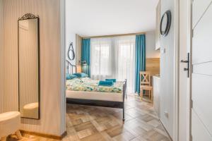 a bedroom with a bed and a mirror at APARTAMENT MEWA in Sztutowo