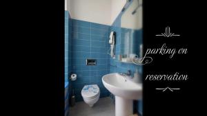 a blue tiled bathroom with a sink and a toilet at Il Quadrifoglio guesthouse in La Spezia