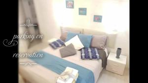 Schlafzimmer mit einem Bett mit blauen und weißen Kissen in der Unterkunft Il Quadrifoglio guesthouse in La Spezia