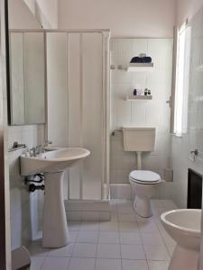 ラスカリにあるAlter Egoの白いバスルーム(トイレ、シンク付)