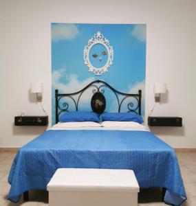 une chambre bleue avec un lit doté d'une tête de lit bleue dans l'établissement Alter Ego, à Lascari