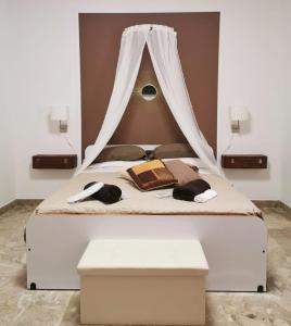 - une chambre avec un lit à baldaquin dans l'établissement Alter Ego, à Lascari