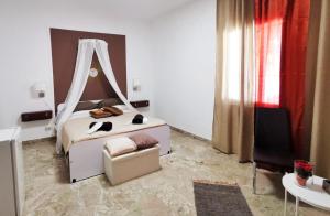 a bedroom with a bed and a chair in it at Alter Ego in Lascari