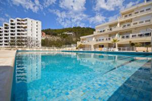 a large swimming pool in front of a building at BEACH house in Sesimbra