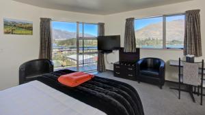 a bedroom with a bed and a view of the mountains at Alexis Motel & Apartments in Queenstown