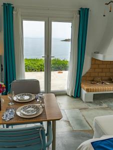 uma sala de jantar com uma mesa e vista para o oceano em Seafront Villa Polyxene em Keratea