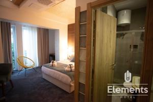 pokój hotelowy z łóżkiem i szklanymi drzwiami w obiekcie Hotel Elements w mieście Novi Pazar
