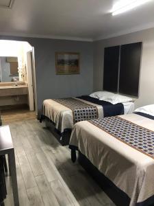 Una habitación de hotel con dos camas y un lavabo. en SouthTown S.A. Inn, en San Antonio