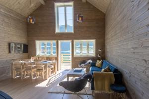 a living room with a blue couch and a table at Reine seaview cabin in Reine