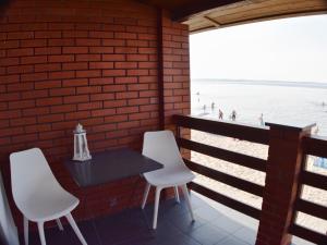 a table and two white chairs and the beach at Zakotwiczeni in Rewa