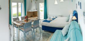 um quarto com uma cama, uma mesa e cadeiras em Seafront Villa Polyxene em Keratea